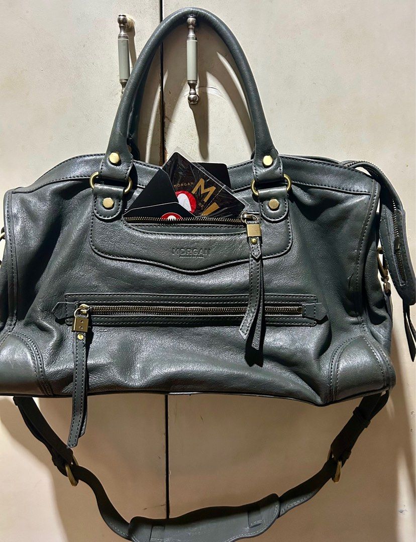 Morgan de Toi Handbag (Category: Luxury Bags & Wallets) located in Quezon City. Submitted by asiaco (Listing ID 1395437041, Image 1). Description: - Morgan de Toi handbag - Dark grey color - Top handle and detachable shoulder strap - Multiple compartments for organization - Interior lining with brand pattern - Gold-colored hardware and zipper closures.