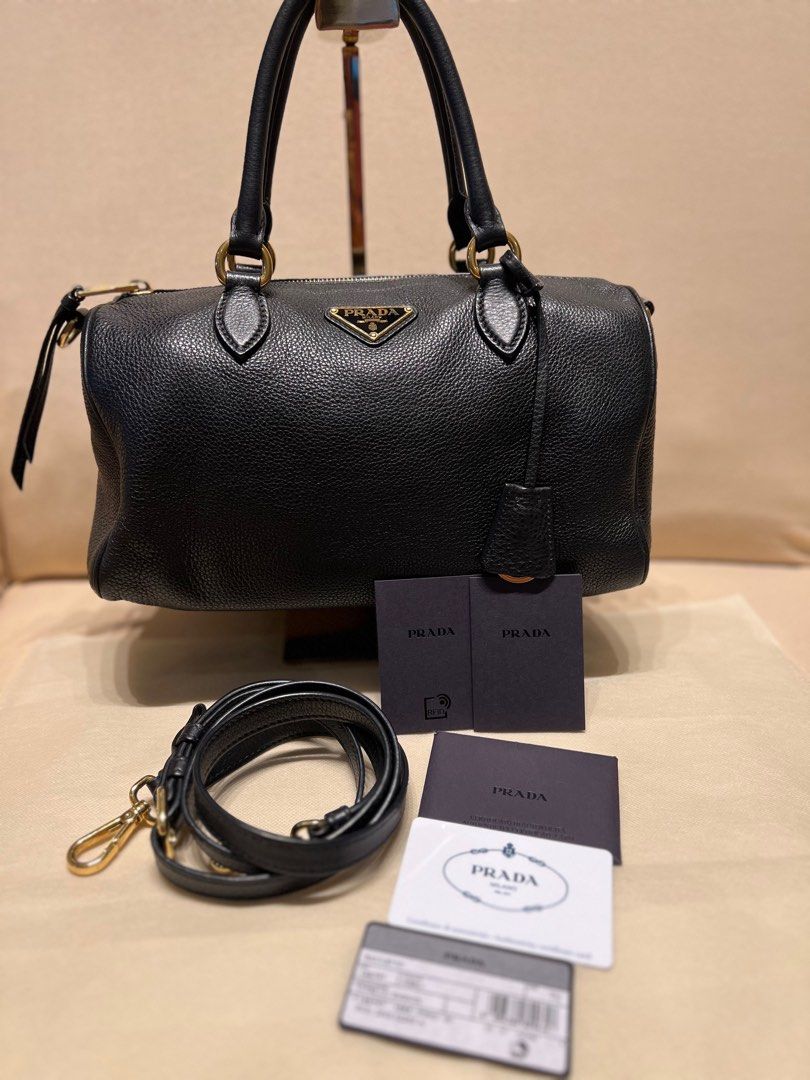 Prada Bauletto Vitello Phenix Black Handbag (Category: Luxury Bags & Wallets) located in Bacoor. Submitted by majezticos (Listing ID 1395496001, Image 1). Description: - Authentic Prada Bauletto handbag - Black Vitello Phenix leather - Gold-tone hardware - Detachable shoulder strap - Multiple interior compartments - Top zip closure - Dual top handles - Includes authenticity cards - Model number: 1BB797 DTI & BIR Registered Business Location : Bac