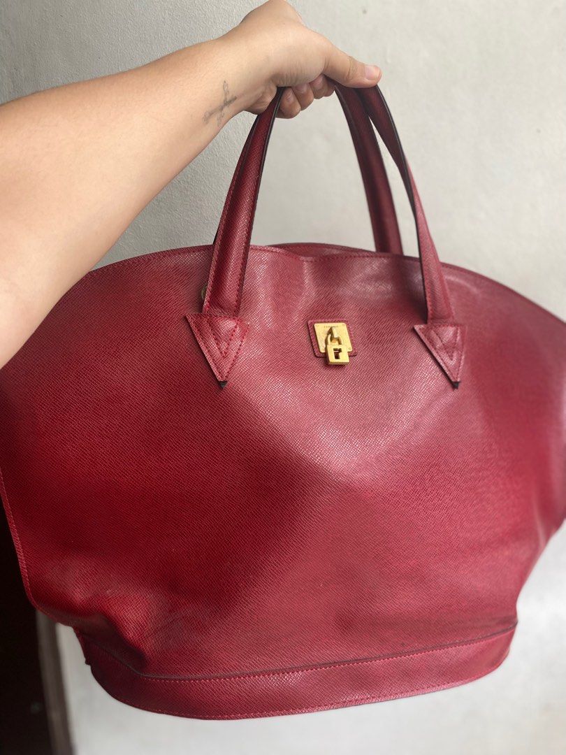 Renoma Large Handbag/Travel bag (Category: Luxury Bags & Wallets) located in Bulacan. Submitted by thriftyhaven2023 (Listing ID 1395372007, Image 3). Description: - Red handbag - Secure lock closure - Sturdy handles - Spacious interior - Textured finish - Classic design - Perfect for travel - Stylish accessory.