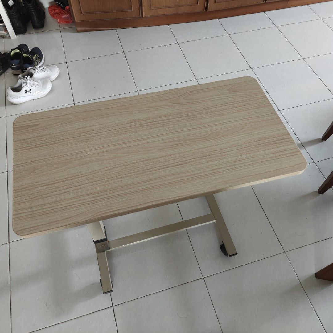 Adjustable Height Bedside Rolling Table (Category: Tables & Sets) located in Singapore. Submitted by vivadeals (Listing ID 1390415643, Image 1). Description: -Best table for serving food and having to eat in bed - Adjustable height - Mobile with wheels - Wood-grain table - Suitable for bedside use - Good condition.