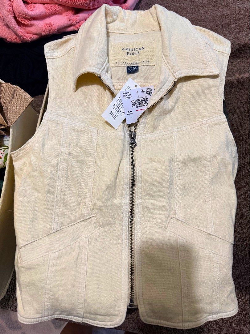 American Eagle Cream Denim Vest (Category: Coats, Jackets and Outerwear) located in Antipolo. Submitted by articlesbyeve (Listing ID 1395594248, Image 1). Description: - American Eagle cream denim vest - Size: XS - Features: Zip-up front, collared neckline, two front pockets - Condition: Brand new with original tag.