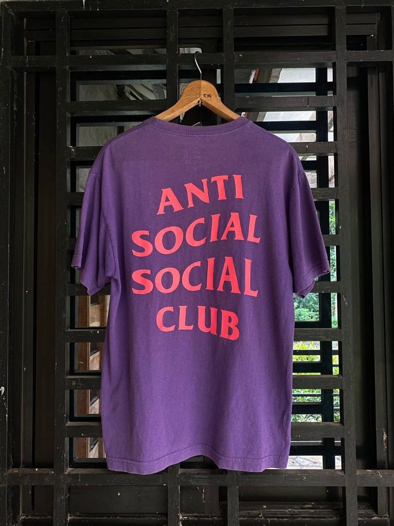 Anti Social Social Club Purple Tee (Category: Tshirts & Polo Shirts ) located in Sariaya. Submitted by hnw_19 (Listing ID 1395549224, Image 1). Description: Purple Anti Social Social Club t-shirt with red lettering. Features the brand's logo on the back. The shirt is hanging on a wooden hanger..
