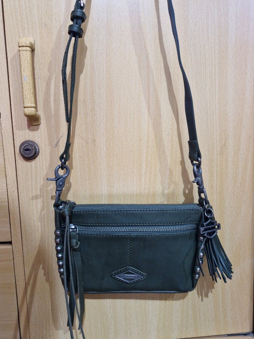 Harley-Davidson Ball & Chain Crossbody Bag (Category: Cross-body Bags) located in Muntinlupa City. Submitted by kmrod (Listing ID 1395571219, Image 1). Description: Harley-Davidson crossbody bag features a stylish design with a detachable strap zippered main compartment and an additional front pocket. adorned with metal studs and a Harley-Davidson logo charm. lined with a patterned fabric. made of genuine leather, Made in India - hard to find! be