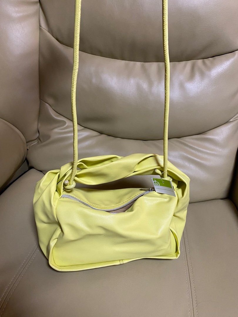 Japan Brand Yellow Twisted Handle Bag (Category: Tote Bags) located in Paranaque City. Submitted by ceceandphoebe (Listing ID 1395567959, Image 1). Description: - Stylish yellow handbag - Unique twisted handle design - Zippered closure - Soft, possibly faux leather material - Adds a pop of color to any outfit - Bought in Japan.