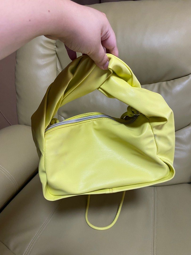 Japan Brand Yellow Twisted Handle Bag (Category: Tote Bags) located in Paranaque City. Submitted by ceceandphoebe (Listing ID 1395567959, Image 2). Description: - Stylish yellow handbag - Unique twisted handle design - Zippered closure - Soft, possibly faux leather material - Adds a pop of color to any outfit - Bought in Japan.