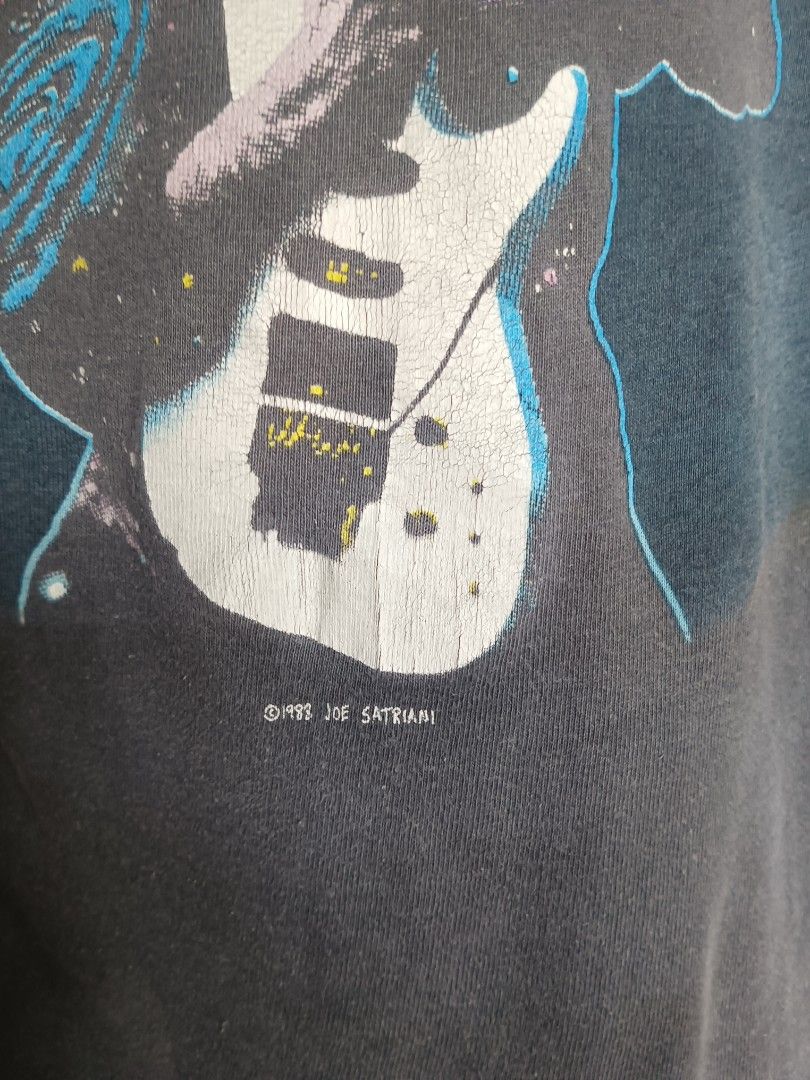 Joe Satriani Graphic Tee (Category: Tshirts & Polo Shirts ) located in Manila. Submitted by _fashionforward_ (Listing ID 1395582404, Image 2). Description: - Vintage Joe Satriani graphic tee - Features a graphic of Joe Satriani playing guitar - Copyright date: 1993 - Color: Dark grey - Style: Crew neck, short sleeves.