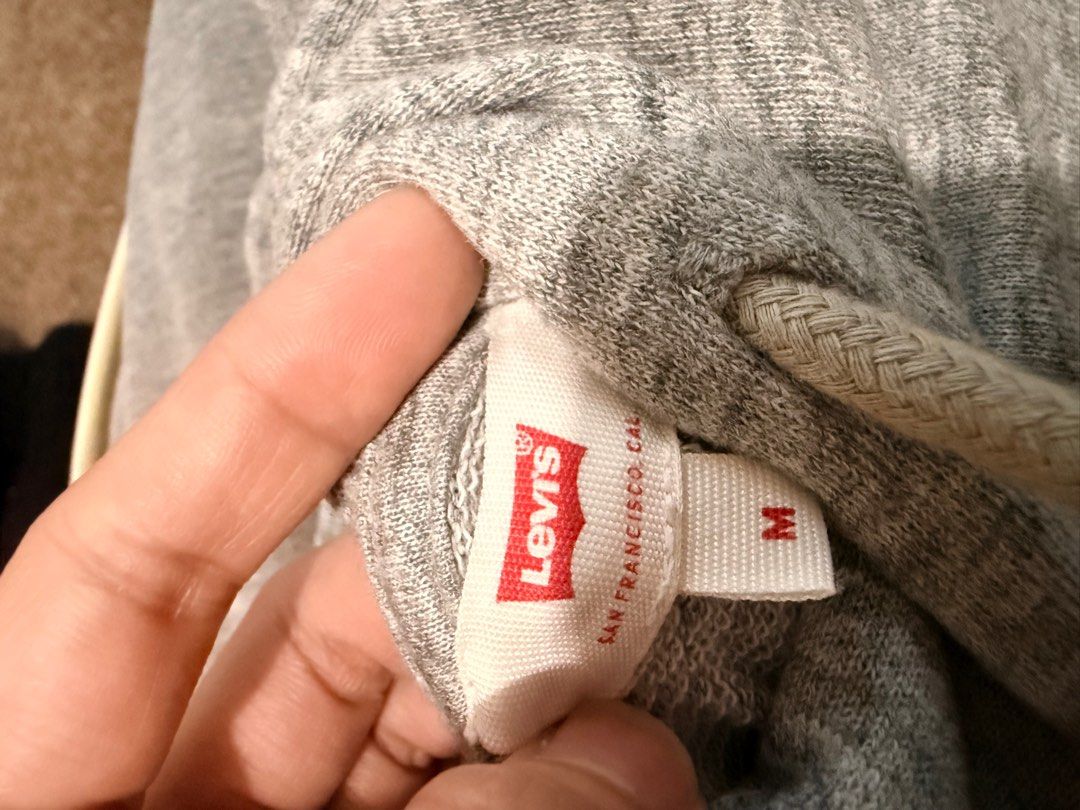 Levi's Gray Hoodie (Category: Hoodies) located in Antipolo. Submitted by articlesbyeve (Listing ID 1395594412, Image 2). Description: - Gray Levi's hoodie - Red logo on front - Size: Medium - Drawstring hood - Soft material - Perfect for casual wear.