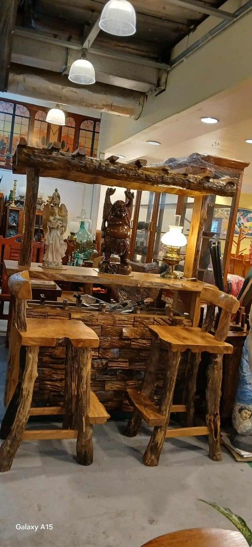 Rustic Wooden Bar Set with Stools (Category: Chairs) located in Paranaque City. Submitted by krghpro (Listing ID 1395587886, Image 1). Description: - Natural wood bar set. - Includes bar counter with textured front. - Features built-in cabinet and top shelf. - Comes with three matching bar stools. - Perfect for home bars and entertainment areas. Molave solid with 3 benches .L = 5ft. W= 20" H = 41" Full height = 73" .