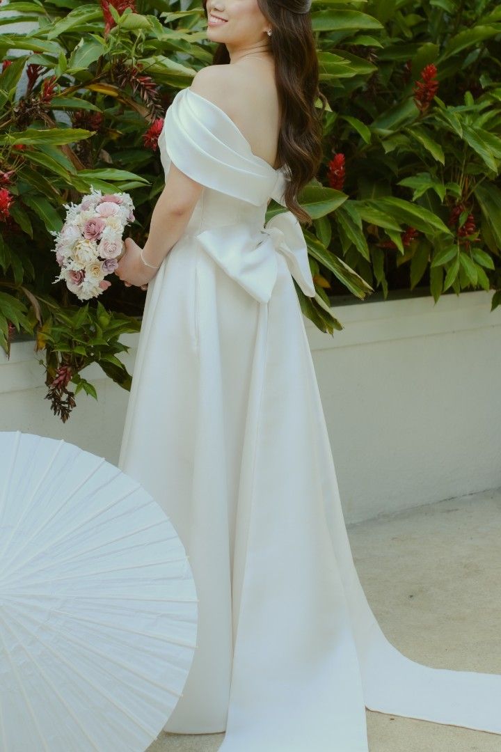 Wedding Gown Classic Mimimalist (Category: Evening dresses & gowns) located in Makati City. Submitted by stufflookup (Listing ID 1390617397, Image 1). Description: My wedding gown is finally up for RENT! I swear, I received countless compliments on this, kulang na lang i-try din nila 😂 Used last April 2025 Designer: Lauren Vito Original price was 50k+ Deposit: 20k Can be worn in 3 ways 🤗 This gown features: 1. detachable sleeves (hand-sown yung
