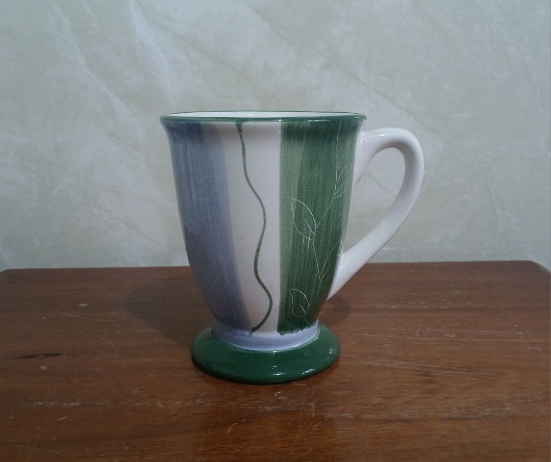 Vintage Style Footed Coffee Mug (Category: Coffee & Tea Tableware) located in Bulacan. Submitted by honhonliz (Listing ID 1391197853, Image 2). Description: Brand new. Never been used, kept in stored cabinet. Original box damaged, cn't be included. Last photo, for vintage proof of this mug only 😊 Material: It appears to be made of ceramic or porcelain, common materials for coffee mugs. Design: The mug features a footed base and a decorative patt