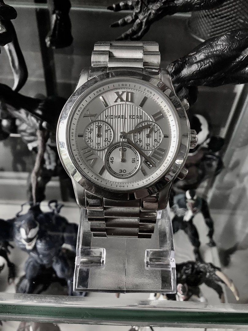 Michael Kors Cooper MK6273 wristwatch (Category: Women's Watches) located in Roxas. Submitted by lutrelle (Listing ID 1391423646, Image 1). Description: This is a Michael Kors Cooper MK6273 wristwatch. ® • Design: It features a silver-tone stainless steel case and bracelet, with a glossy finish on the case and a matching silver dial. • • Features: The watch includes a chronograph with a stopwatch function and is water-resistant. o • Movement: It 
