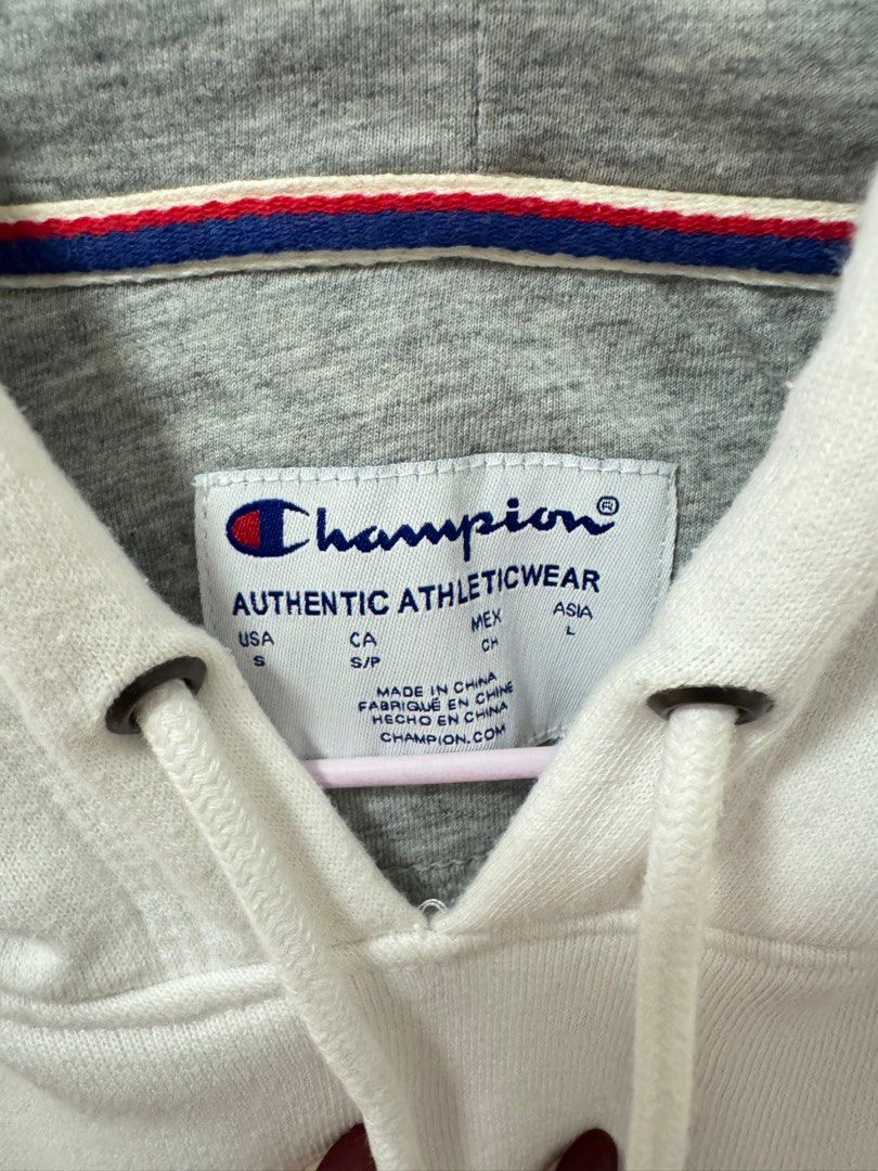 Champion Hoodie - White (Category: Hoodies) located in Caloocan City. Submitted by shop.ae (Listing ID 1412882794, Image 2). Description: - Champion hoodie - Size: Small (S) - Features the Champion logo - Kangaroo pocket - Drawstring hood - Grey inner hood lining - Classic and comfortable design.