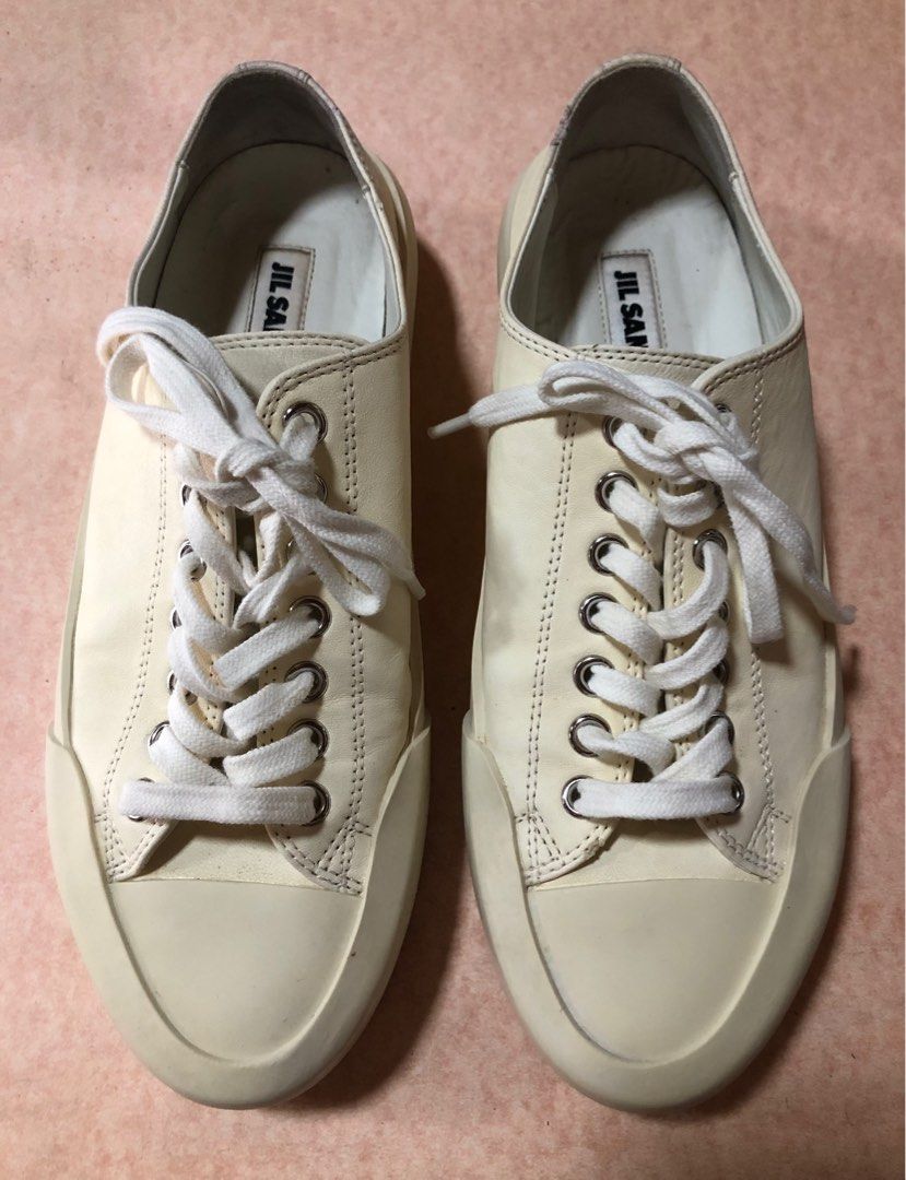 Jil Sander Soft Leather Cream Sneakers (Category: Sneakers) located in Manila. Submitted by az_09.2024 (Listing ID 1412957057, Image 1). Description: - Cream-colored Jil Sander sneakers - Features Jil Sander logo on insole and sole - Thick sole design - Lace-up closure - W /small tiny wear on one side as shown but still in a very good condition overall. - Jil Sander logo on the back of the shoes.