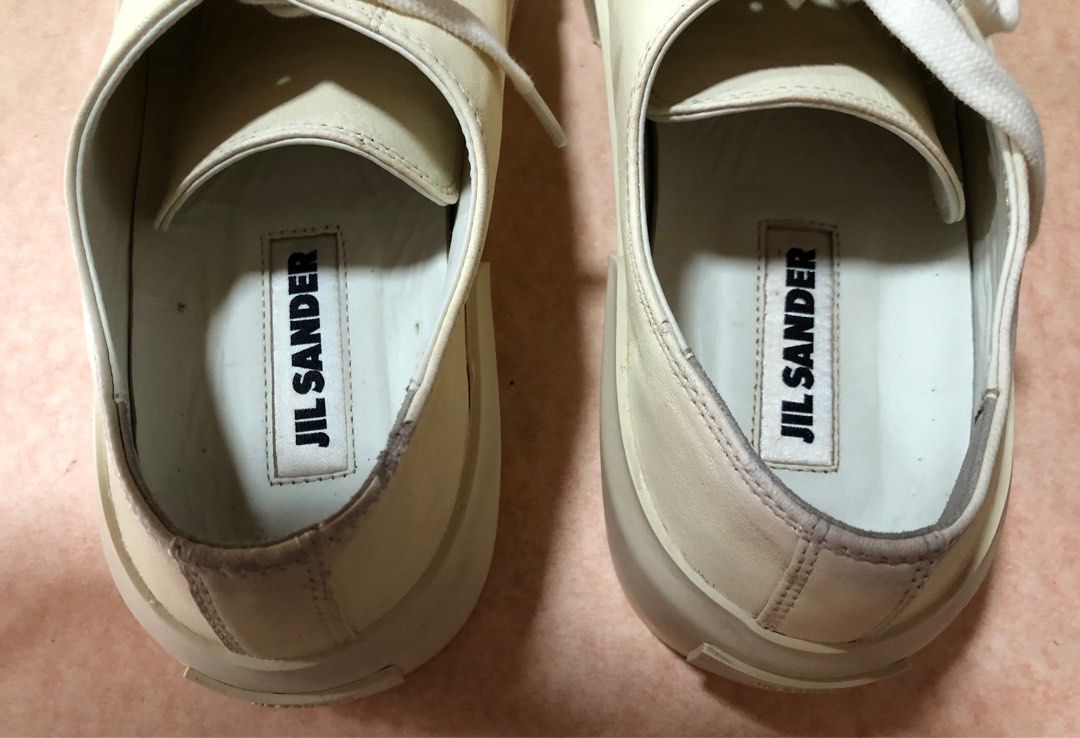 Jil Sander Soft Leather Cream Sneakers (Category: Sneakers) located in Manila. Submitted by az_09.2024 (Listing ID 1412957057, Image 2). Description: - Cream-colored Jil Sander sneakers - Features Jil Sander logo on insole and sole - Thick sole design - Lace-up closure - W /small tiny wear on one side as shown but still in a very good condition overall. - Jil Sander logo on the back of the shoes.