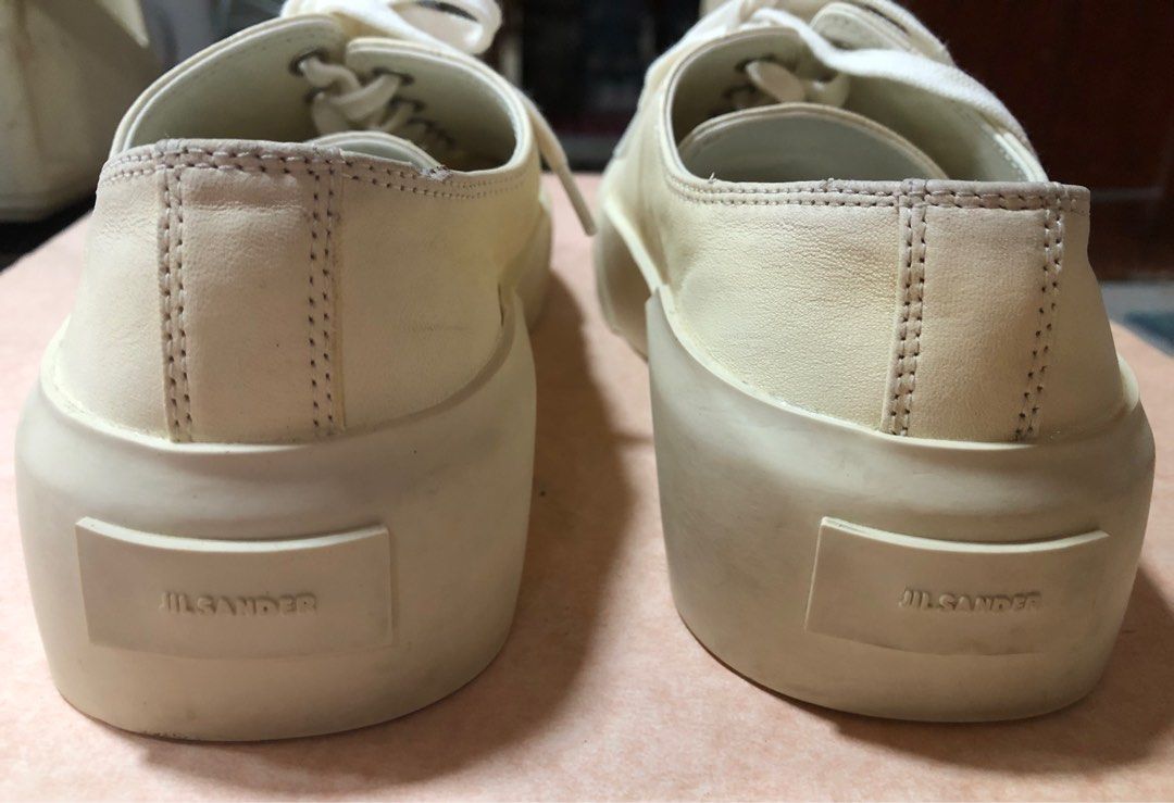 Jil Sander Soft Leather Cream Sneakers (Category: Sneakers) located in Manila. Submitted by az_09.2024 (Listing ID 1412957057, Image 3). Description: - Cream-colored Jil Sander sneakers - Features Jil Sander logo on insole and sole - Thick sole design - Lace-up closure - W /small tiny wear on one side as shown but still in a very good condition overall. - Jil Sander logo on the back of the shoes.
