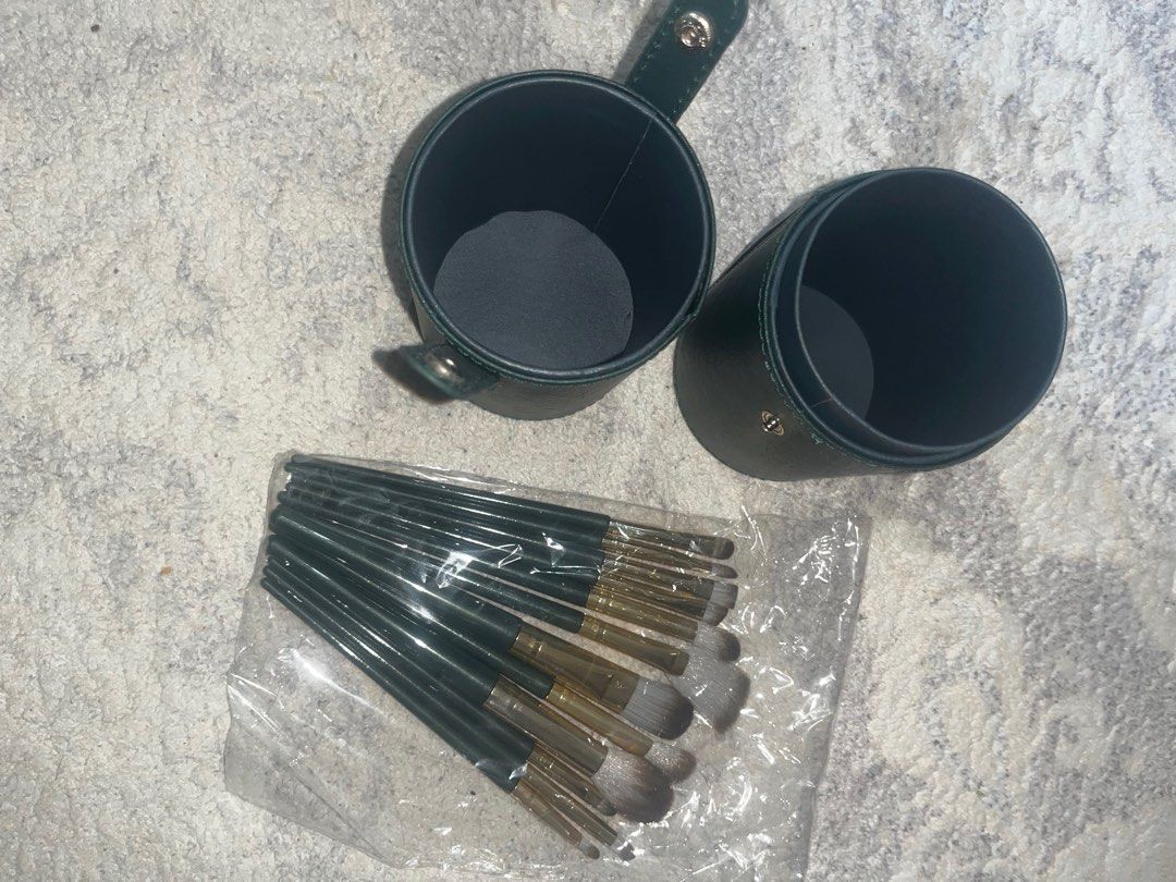 Makeup Brush Set with Leather Holder (Category: Makeup) located in Rizal. Submitted by cassappl (Listing ID 1412910166, Image 2). Description: - Makeup brush set - Includes a variety of brush types (12pcs total) - Comes with a dark green cylindrical case with a handle - Brushes feature gold and dark green handles.