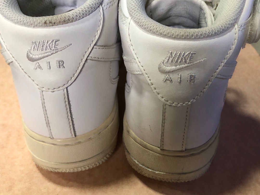 Nike Air Force 1 High Top White Sneakers (Category: Sneakers) located in Manila. Submitted by az_09.2024 (Listing ID 1412950280, Image 3). Description: - White Nike Air Force 1 high-top sneakers - US size 8.5 - Iconic Air Force 1 design - "AF1" metal tag on laces - White leather upper - Perforated toe box - Nike Air logo on the back.