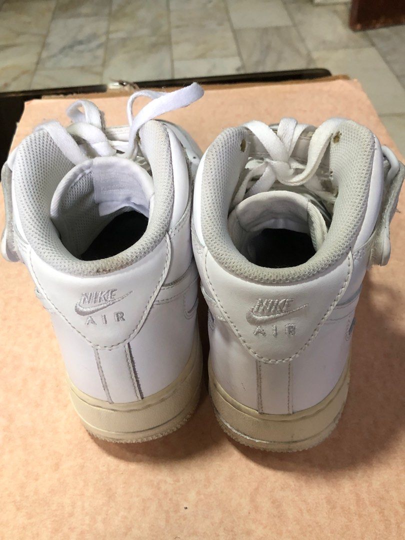 Nike Air Force 1 High Top White Sneakers (Category: Sneakers) located in Manila. Submitted by az_09.2024 (Listing ID 1412950280, Image 2). Description: - White Nike Air Force 1 high-top sneakers - US size 8.5 - Iconic Air Force 1 design - "AF1" metal tag on laces - White leather upper - Perforated toe box - Nike Air logo on the back.