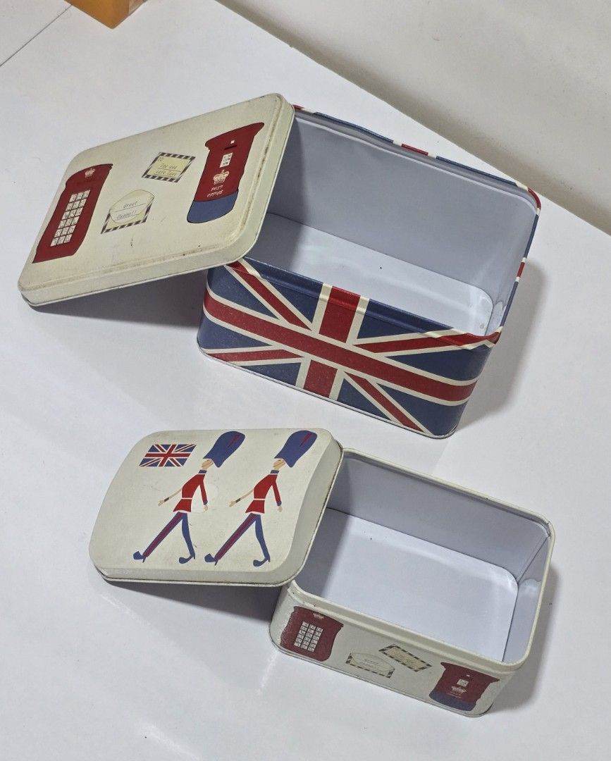 UK-inspired Storage Tin Boxes Organizers (Category: Storage Boxes & Baskets) located in San Fernando. Submitted by sophmng (Listing ID 1412916968, Image 2). Description: Price listed is for the SET! - UK-inspired storage tin boxes. - Features iconic British designs (Union Jack, phone booths, guards). - Stylish and functional. - Perfect for organizing small items. Big box dimensions: 19cm L x 13.5cm D x 12.5cmH Small box dimensions: 14.5cm L x 10.
