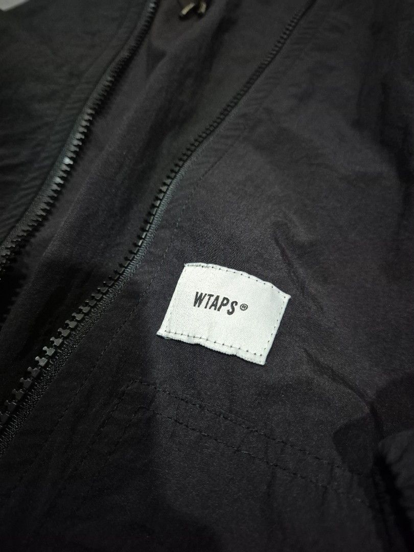 WTAPS (Category: Coats, Jackets and Outerwear) located in Kuala Lumpur. Submitted by satayhut (Listing ID 1412987641, Image 2). Description: - WTAPS black hooded jacket - Size: X 01 - Made in Japan - Full zip closure - WTAPS logo patch on chest and back - Drawstring hood - Lightweight material.