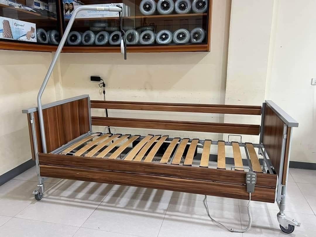 Adjustable Hospital Bed with Wheels (Category: Medical Supplies & Tools) located in Manila. Submitted by gracepangan_02 (Listing ID 1414688781, Image 3). Description: - Adjustable hospital bed - Wooden frame - Slatted base - Includes side table - Overhead support arm included - Features wheels for easy movement - Control panel for adjustments - Ideal for patient care and comfort.