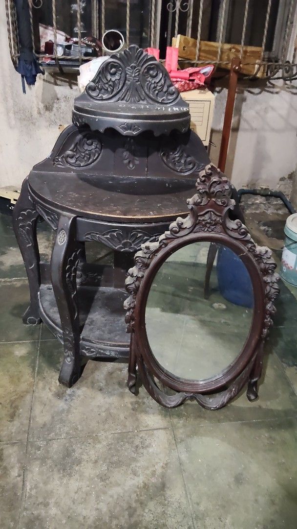 Antique Table with Oval Mirror (Category: Tables & Sets) located in Quezon City. Submitted by nobleriver_94656c (Listing ID 1414814763, Image 3). Description: - Antique table with attached shelf - Intricate carvings - Includes matching oval mirror - Decorative frame on mirror - Detailed leg design - Dark finish - Adds vintage charm.