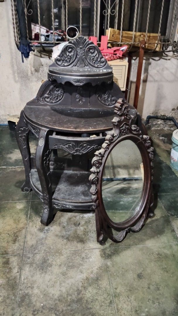 Antique Table with Oval Mirror (Category: Tables & Sets) located in Quezon City. Submitted by nobleriver_94656c (Listing ID 1414814763, Image 2). Description: - Antique table with attached shelf - Intricate carvings - Includes matching oval mirror - Decorative frame on mirror - Detailed leg design - Dark finish - Adds vintage charm.