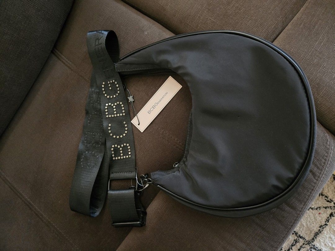 BcBG Bag Selling Low (lost strap) (Category: Luxury Bags & Wallets) located in Quezon City. Submitted by mgdeclutters (Listing ID 1414730875, Image 1). Description: - BCBG Generation handbag - Crescent shape - Black nylon exterior - Zippered closure - Includes brand tag selling low: lost bag strap.