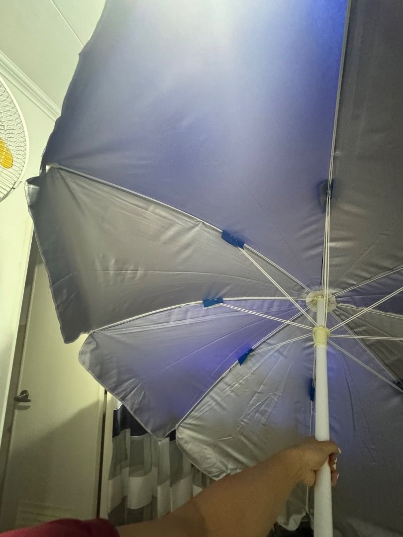 Beach Umbrella - Blue and Silver (Category: Umbrellas) located in Cavite. Submitted by royaleagle-7269 (Listing ID 1414787138, Image 3). Description: - Vibrant blue and silver color scheme - Sturdy white pole - Wide canopy for maximum shade - Folds up for easy storage and transport - Ideal for beach and park use - Provides sun protection.
