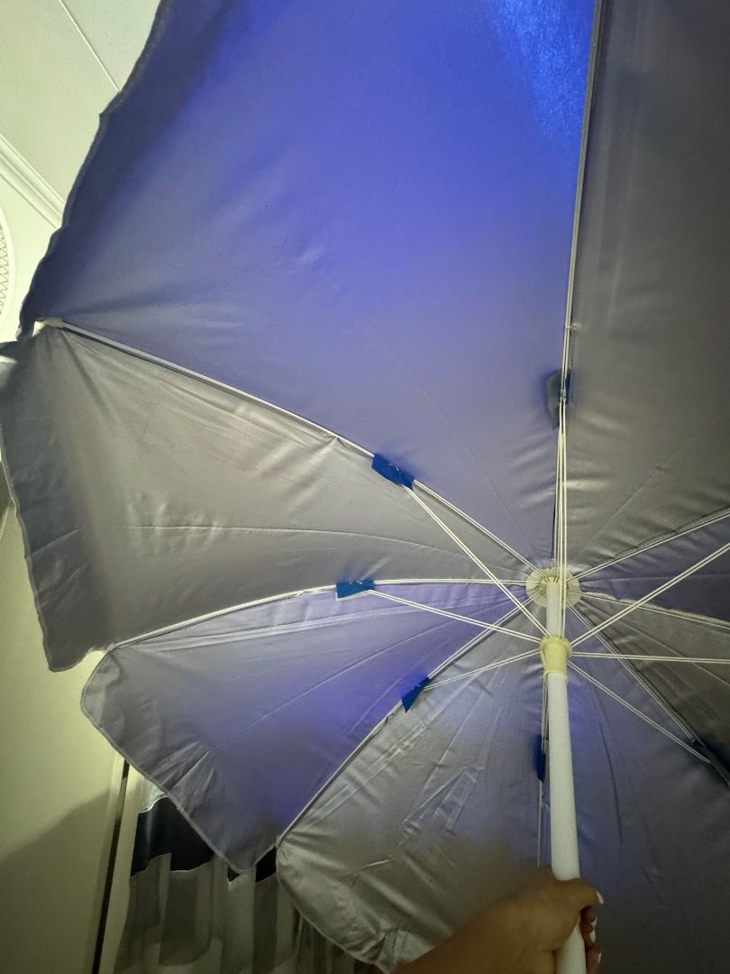 Beach Umbrella - Blue and Silver (Category: Umbrellas) located in Cavite. Submitted by royaleagle-7269 (Listing ID 1414787138, Image 2). Description: - Vibrant blue and silver color scheme - Sturdy white pole - Wide canopy for maximum shade - Folds up for easy storage and transport - Ideal for beach and park use - Provides sun protection.