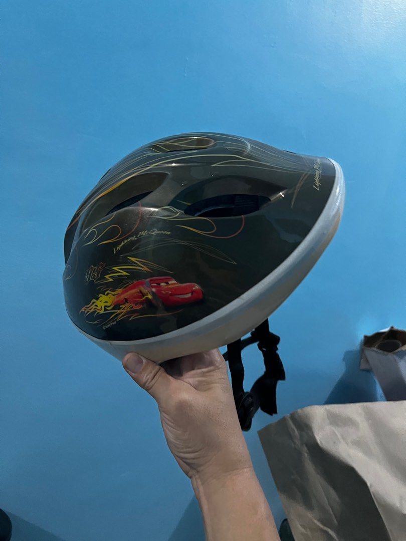 Cars Lightning McQueen Helmet iDES (Category: Helmets and other Riding Gears) located in Pasay City. Submitted by beye01 (Listing ID 1414788669, Image 1). Description: - Lightning McQueen design helmet - Features flame and character graphics - Black base color - White trim - Black strap - Designed for children.