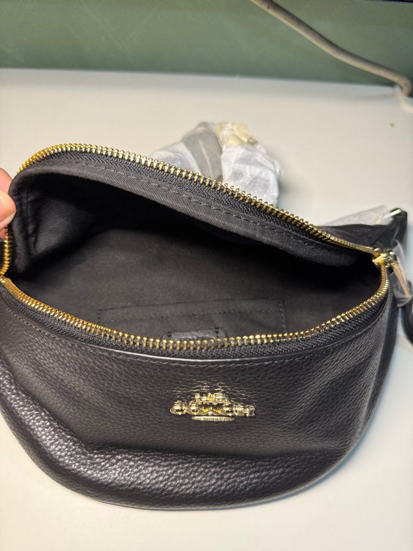Coach Black Leather Waist Bag (Category: Luxury Bags & Wallets) located in Cavite. Submitted by nicainics (Listing ID 1414737183, Image 2). Description: - Brand new Coach waist bag - Crafted from black leather - Elegant gold-tone zipper and hardware - Features a main compartment for essentials - Includes an interior pocket for organization - Comes with a detachable strap for versatile wear - Includes a signature Coach hangtag.
