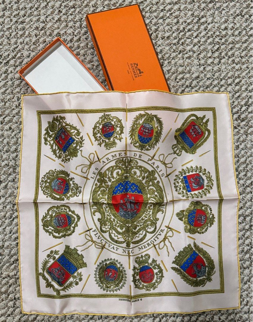 Hermes Les Armes de Paris Silk Scarf (Category: Scarves) located in Manila. Submitted by Authentic_Seller (Listing ID 1412362051, Image 2). Description: Authentic Hermes silk scarf Design: "Les Armes de Paris" Features a central emblem and intricate detailing Color: White background with gold and various colors Includes original orange Hermes box.