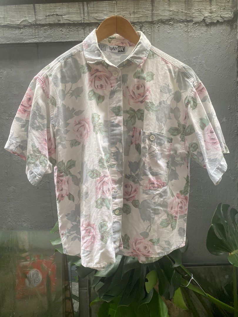 Krazy Kat Floral Shirt - Size S - BUY1TAKE1 (Category: Tshirts & Polo Shirts ) located in Makati City. Submitted by secondhand.bayonets (Listing ID 1414709549, Image 1). Description: - Vintage Krazy Kat shirt - Floral design with pink and green roses - Size: Small - Material: 100% Cotton - Style: Button-down, short sleeves - Features a single chest pocket - Background: White -With tiny small holes on back.