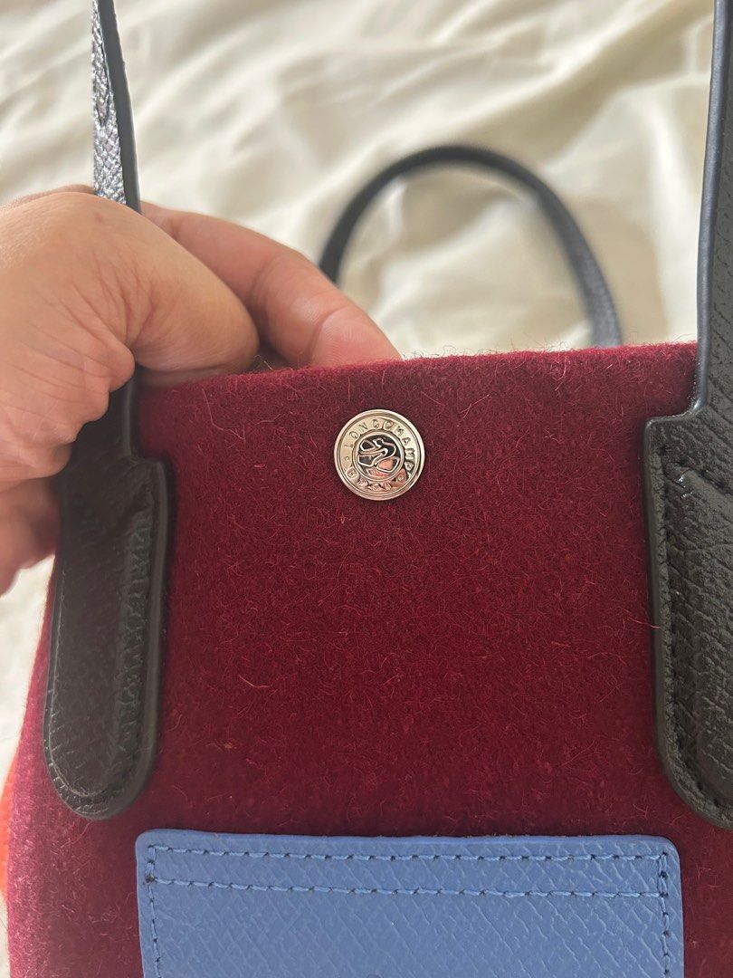 Longchamp Le Pliage Cuir Tote Bag (Category: Luxury Bags & Wallets) located in Cabanatuan. Submitted by krnlim (Listing ID 1414627531, Image 3). Description: Authentic Longchamp Le Pliage Cuir tote bag. Features a burgundy felt body with a blue front pocket and black leather handles. Includes a snap closure and a Longchamp logo on the front pocket and the button. Made in France. The tag shows the model number 10172HBL009..