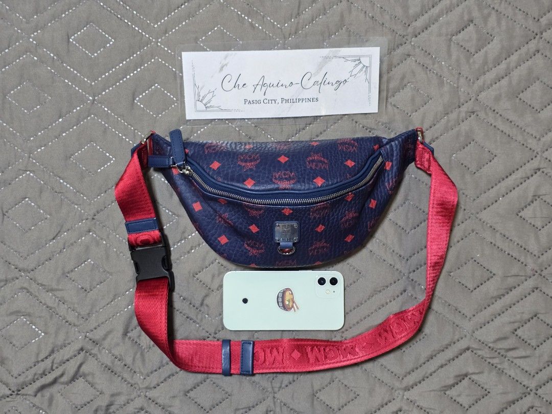 MCM Visetos Belt Bag (Category: Luxury Bags & Wallets) located in Manila. Submitted by lylmaster (Listing ID 1414799419, Image 1). Description: - Authentic MCM Visetos belt bag - Navy blue body with red MCM logo print - Red strap with MCM logo print - Zip closure - Buckle closure - Ideal for carrying essentials.