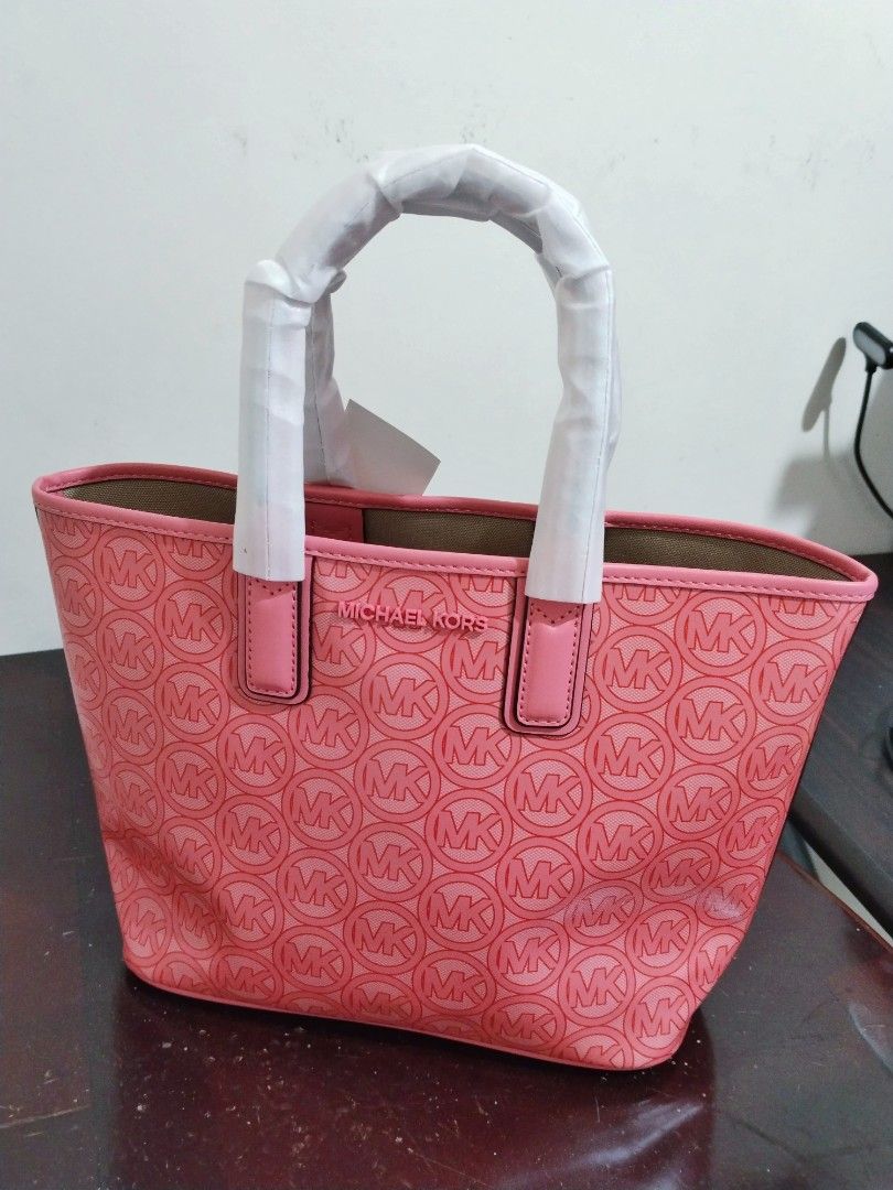 Michael Kors Jodie SM Tote - Grapefruit (Category: Tote Bags) located in Manila. Submitted by jovyjing (Listing ID 1414687596, Image 2). Description: - Authentic Michael Kors Jodie SM Tote - Color: Grapefruit - Features MK logo pattern - Includes original tags - Top handle design - Spacious interior - Made with recycled materials - Original price: "$348".