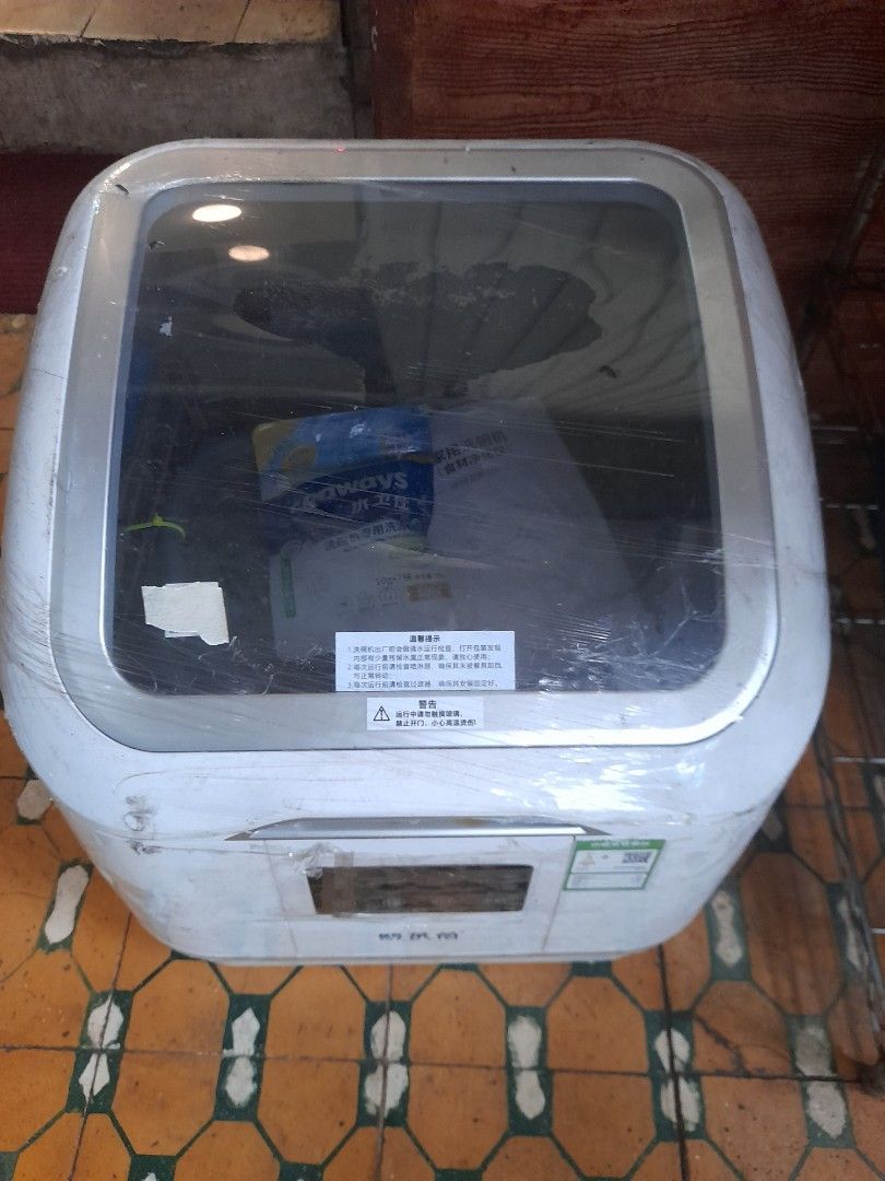 OLEVIN Dishwasher (Category: Dishwasher) located in Valenzuela. Submitted by newbear.425b6e (Listing ID 1414717295, Image 2). Description: - Includes user manual - Comes with a pack of dishwashing tablets - Features a clear door - Control panel with multiple buttons - Dish rack inside for organized washing - Includes a hose - Stylish white exterior with silver trim.