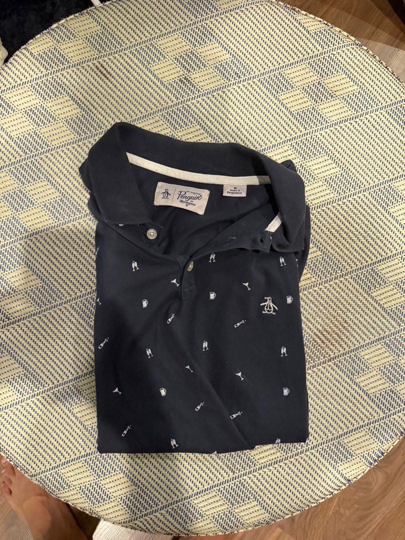 Original Penguin Polo Shirt - Medium (Category: Tshirts & Polo Shirts ) located in Taguig. Submitted by e_prc (Listing ID 1414745289, Image 3). Description: - Original Penguin polo shirt - Navy blue with white trim - Features small white icon pattern - Classic polo collar and short sleeves - Size: Medium - Made in Bangladesh - Issue: Fading from iron.