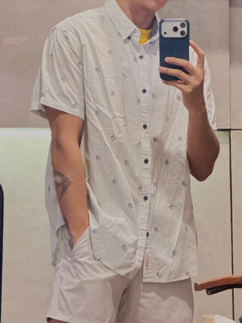 Original Penguin Striped Shirt (Category: Tshirts & Polo Shirts ) located in Taguig. Submitted by e_prc (Listing ID 1414746232, Image 2). Description: - Original Penguin short-sleeved shirt - Size: XL - Color: White with black stripes and penguin print - Features: Button-down, collar, chest pocket - Fit: Relaxed.