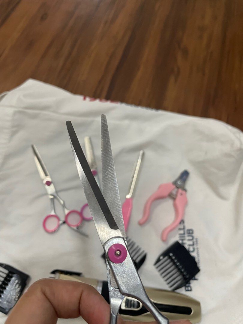 Pet Grooming Kit (Category: Homes & Other Pet Accessories) located in Manila. Submitted by jinsnow_ (Listing ID 1414802893, Image 3). Description: - Complete pet grooming kit for home use. - Includes clippers with adjustable blade and dog design. - Comes with three pairs of scissors with pink accents. - Features pink nail clippers and a nail file. - Includes clipper comb attachments. No issue. RFS: Declutter.