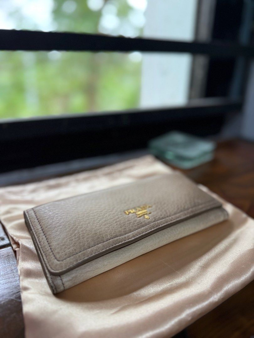 SALE! Authentic Prada Long Wallet (Gradient Beige) (Category: Luxury Bags & Wallets) located in Binangonan. Submitted by pinkesceeluxe (Listing ID 1414691528, Image 2). Description: - Authentic Prada long wallet - Soft Leather - Gradient Beige leather exterior with some scratches - Gold-tone hardware (gold na gold pa, no tarnishings) - Multiple card slots - Zippered compartment - No glazing. Rubber lining is in tact - Includes original tags and g