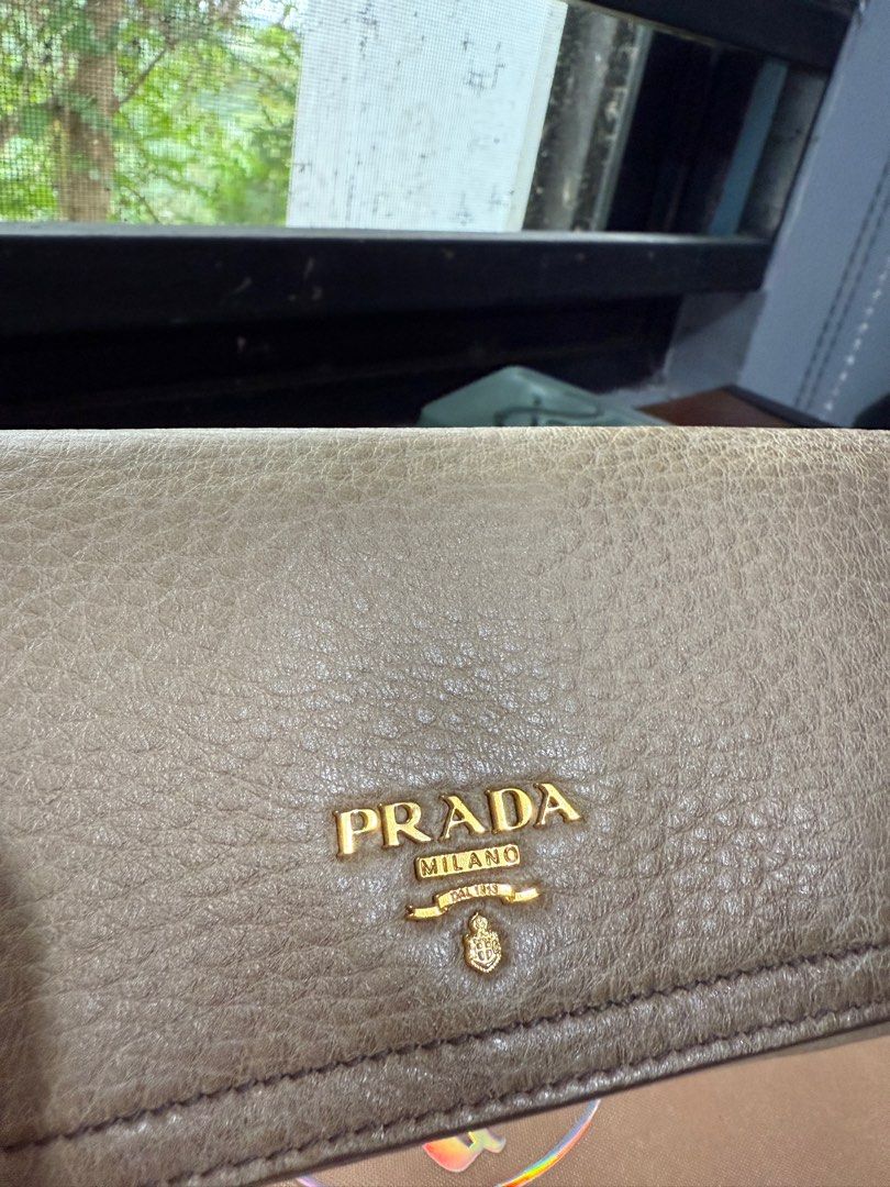 SALE! Authentic Prada Long Wallet (Gradient Beige) (Category: Luxury Bags & Wallets) located in Binangonan. Submitted by pinkesceeluxe (Listing ID 1414691528, Image 3). Description: - Authentic Prada long wallet - Soft Leather - Gradient Beige leather exterior with some scratches - Gold-tone hardware (gold na gold pa, no tarnishings) - Multiple card slots - Zippered compartment - No glazing. Rubber lining is in tact - Includes original tags and g
