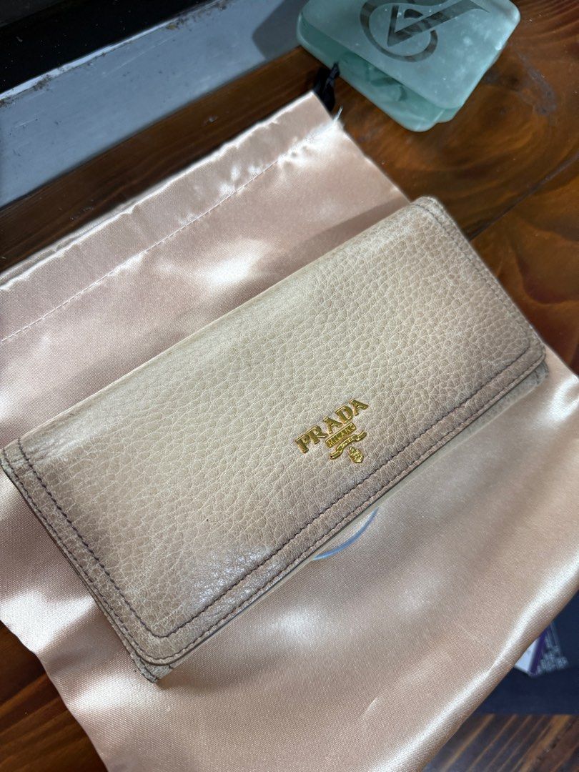 SALE! Authentic Prada Long Wallet (Gradient Beige) (Category: Luxury Bags & Wallets) located in Binangonan. Submitted by pinkesceeluxe (Listing ID 1414691528, Image 1). Description: - Authentic Prada long wallet - Soft Leather - Gradient Beige leather exterior with some scratches - Gold-tone hardware (gold na gold pa, no tarnishings) - Multiple card slots - Zippered compartment - No glazing. Rubber lining is in tact - Includes original tags and g