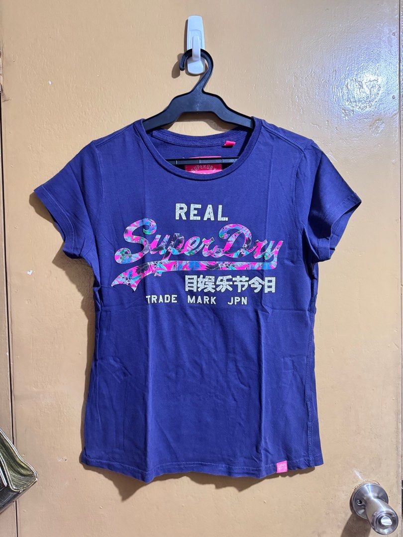 Superdry Real T-shirt - Medium (Category: Shirts) located in Pasig City. Submitted by cafeverona333 (Listing ID 1414625391, Image 1). Description: - Authentic Superdry t-shirt - Vibrant blue color - Features "Real Superdry" logo with floral accents - Size: Medium (M) - Crew neck and short sleeves - British Design, Spirit of Japan GPayment or BPI QR Meet up in Greenbelt (T/TH) or Estancia Mall (weekend) Lala Grab LBC (Buyers Expense) Item Location