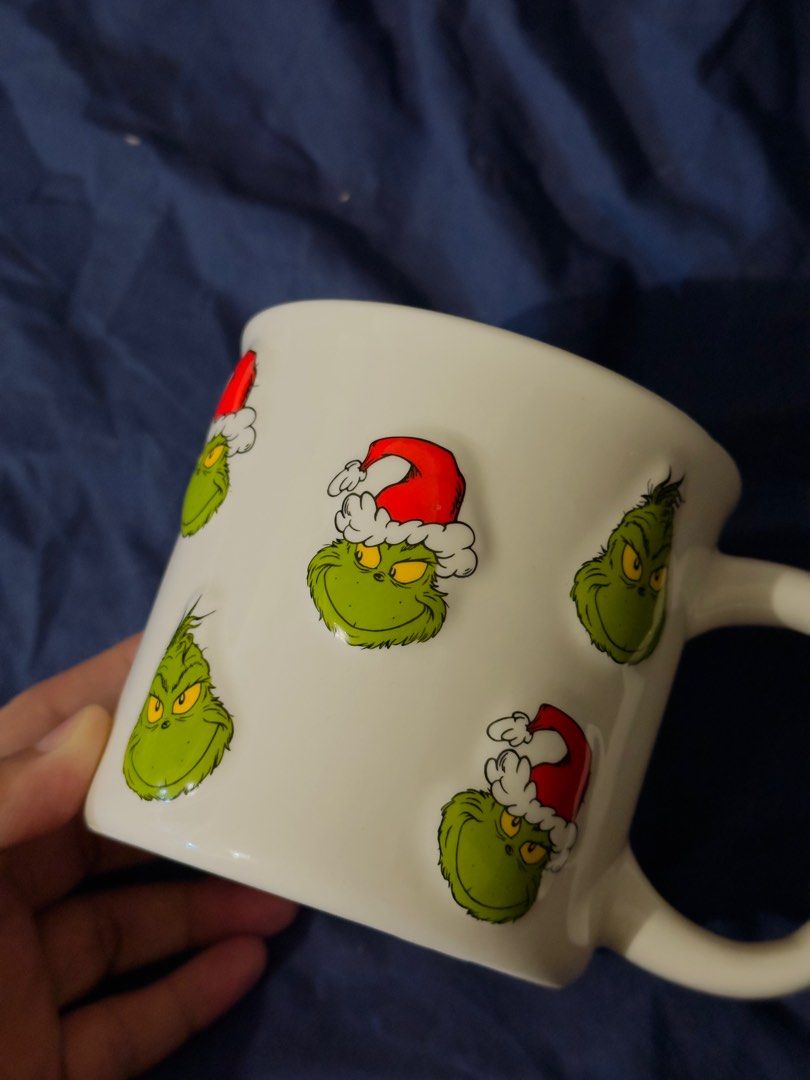 The Grinch Mug Original rare embossed design (Category: Coffee & Tea Tableware) located in Mandaluyong City. Submitted by r_izzy (Listing ID 1414735785, Image 2). Description: - with multiple Grinch face embossed designs. - Features Grinch faces wearing Santa hats. - Officially licensed by Dr. Seuss Enterprises. - Hand wash recommended. - Perfect for Grinch fans and holiday gifting. .