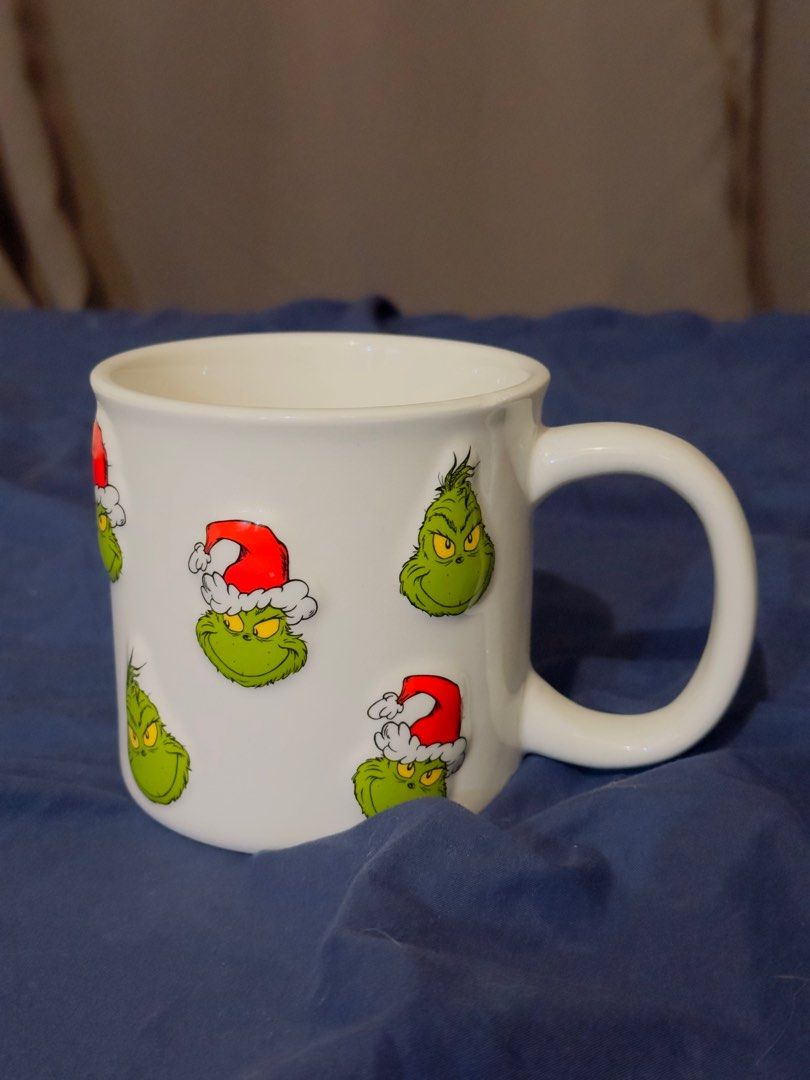 The Grinch Mug Original rare embossed design (Category: Coffee & Tea Tableware) located in Mandaluyong City. Submitted by r_izzy (Listing ID 1414735785, Image 1). Description: - with multiple Grinch face embossed designs. - Features Grinch faces wearing Santa hats. - Officially licensed by Dr. Seuss Enterprises. - Hand wash recommended. - Perfect for Grinch fans and holiday gifting. .