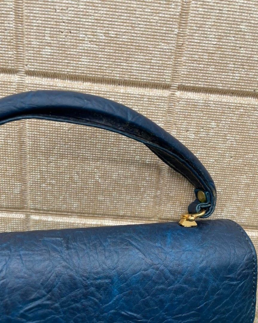 Vintage mini handbag (Category: Luxury Bags & Wallets) located in Quezon City. Submitted by vanessaqu83110 (Listing ID 1414820358, Image 2). Description: - Vintage navy blue handbag - Gold-toned hardware - Top handle - Clasp closure - Red interior - Multiple compartments - Textured material - Structured shape - Classic design.