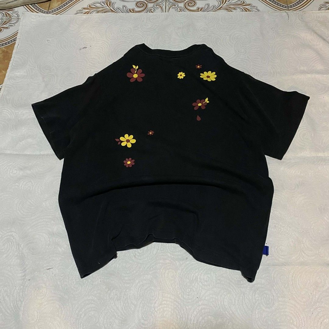 WASSUP (Category: Activewear) located in Hilongos. Submitted by tripnimobe-1 (Listing ID 1414742643, Image 3). Description: - Black H&M t-shirt - Features a floral graphic design - Includes the words "WASSUP POWER" in yellow - Short sleeves - Round neckline - Relaxed fit.