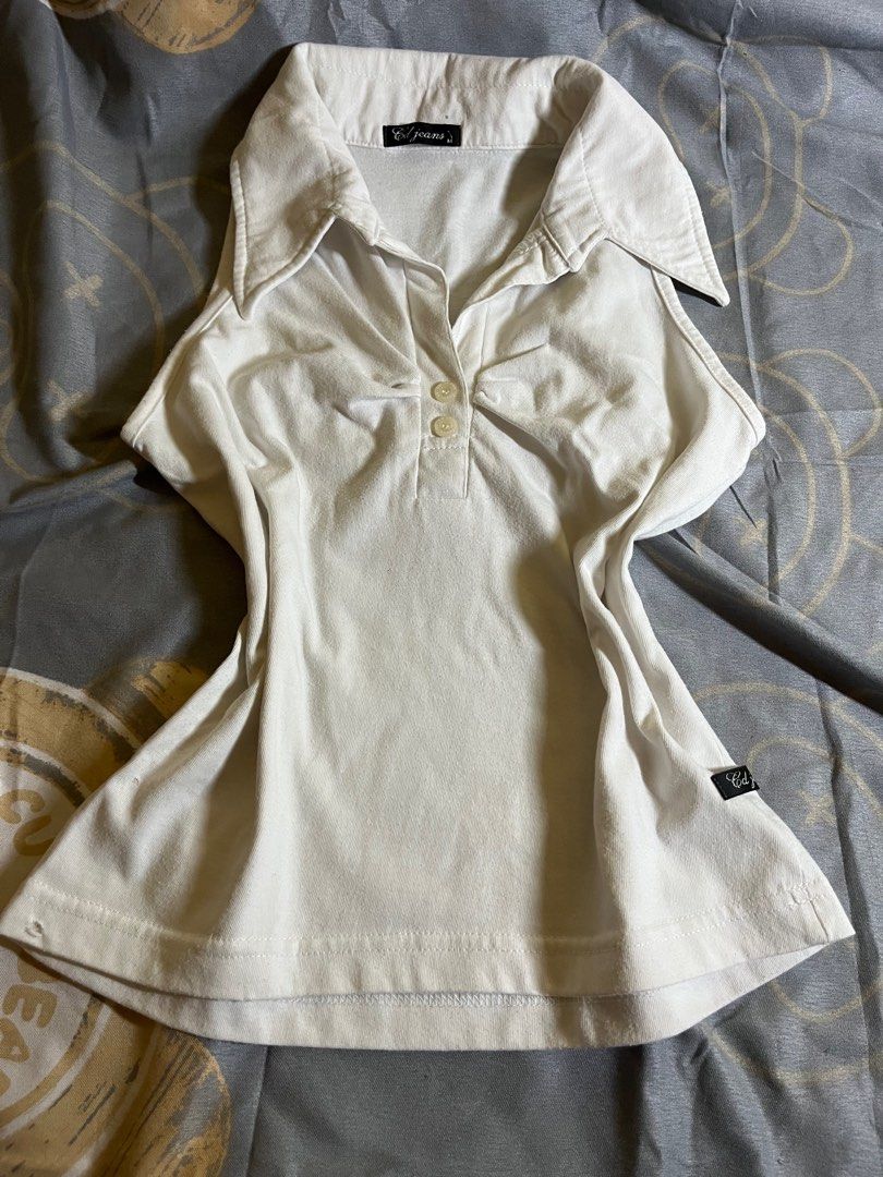 fitted collared sleeveless top (Category: Blouses) located in Manila. Submitted by a22bee (Listing ID 1414684458, Image 1). Description: - White collared top - Button-up front - Fitted silhouette - Small logo detail - Minor flaw: small hole on the side - Soft, likely cotton material mop: gcash mod: lalamove, angkas padala, jnt - can meet around dlsu.